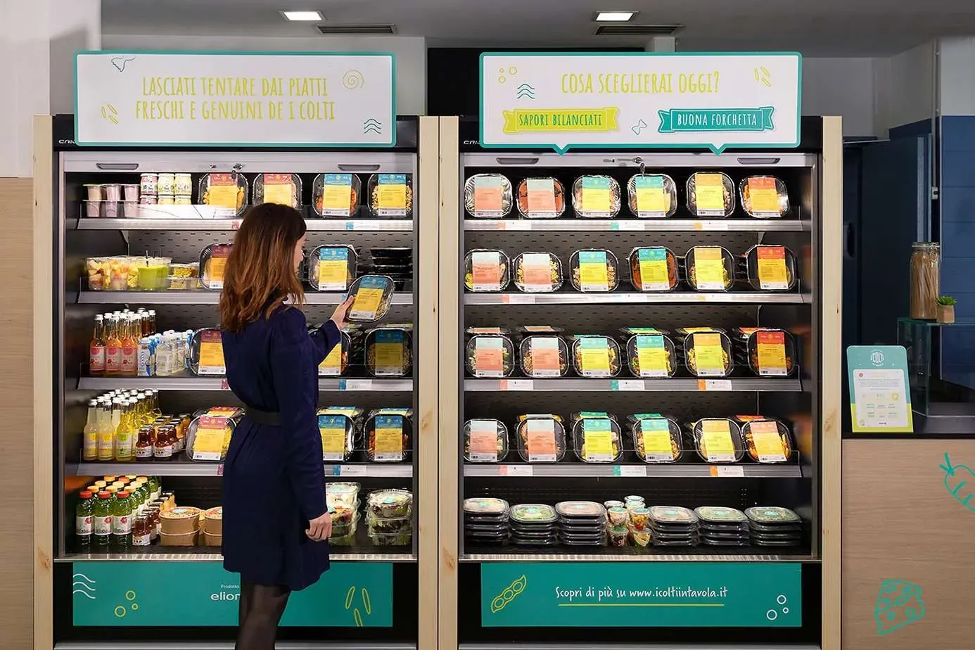 una donna che prende cibo dal frigorifero del supermercato