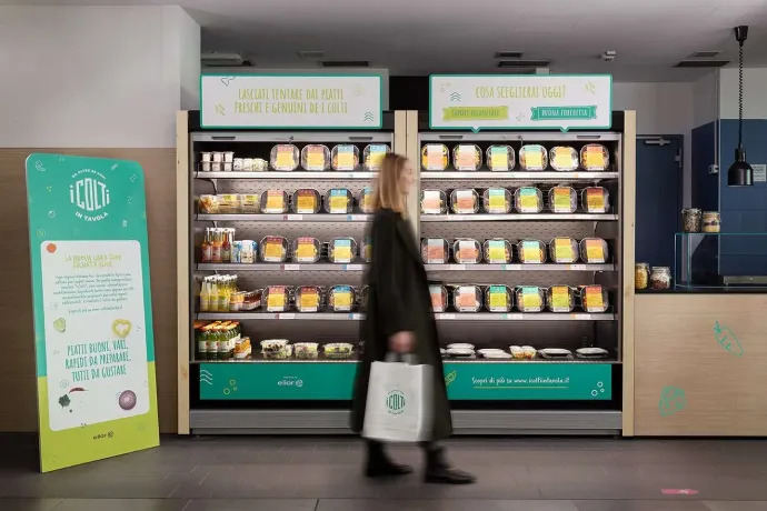 donna che passa davanti al frigorifero del supermercato